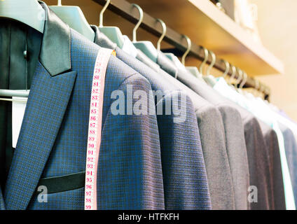 Row of men's suits hanging in closet. Stock Photo