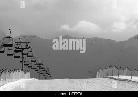 Black and white view on snow skiing piste and ropeway. Caucasus Mountains. Georgia, region Gudauri in evening.