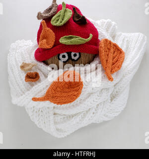 Diy funny, humor Christmas background handmade, lazy snowman from white scarf, red hat, eye, knitted leaf, winter leaves in cold day of Xmas holiday Stock Photo