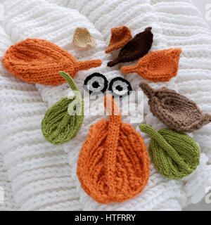 Humor eyes of winter from yarn, diy simple background for Xmas holiday by knitted leaf for eyebrows, nose on white scarf background, funny face craft Stock Photo