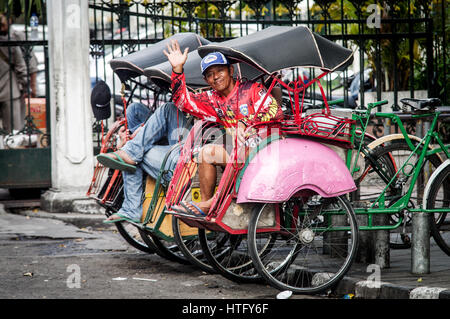 Friendly becak driver giving a wave in Yogyakarta - Java, Indonesia Stock Photo