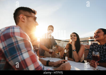Shot of young woman having a rooftop party with friends. Friends party gathering on rooftop. Stock Photo