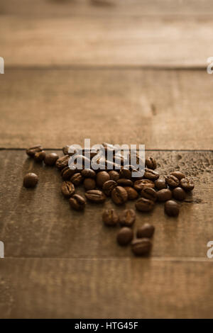 Coffee beans on a wooden background, light grainy and vintage image. Stock Photo