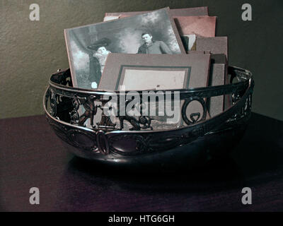 Antique cabinet photo cards in a decorative metal bowl with gargoyle design. Stock Photo