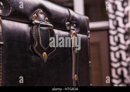 Black vintage suitcase leather texture. Old style bag clasp, buckle and belt closeup Stock Photo