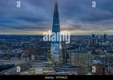 Panoramic aerial view of urban London with the Shard skyscraper and Thames river at sunset against a cloudy sky. London, United Kingdom. Stock Photo