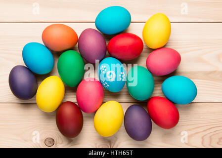 bunch of beautiful colored eggs on a wooden table top view Stock Photo