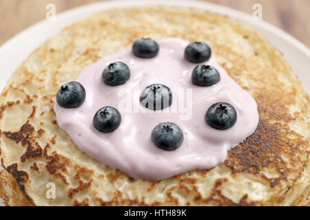 blini or crepes with yogurt and blueberries closeup, sweet breakfast Stock Photo