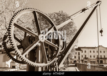 Gear wheels of an old and vintage crane. The crane is located near the small harbor on the lakeside of Luino, Lake Maggiore, Italy Stock Photo