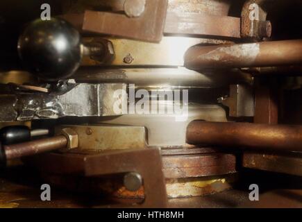 A hot vinyl puck is pressed into a seven inch record in an Alpha Toolex pressing machine at the Vinyl Factory, Hayes, Middlesex. Stock Photo