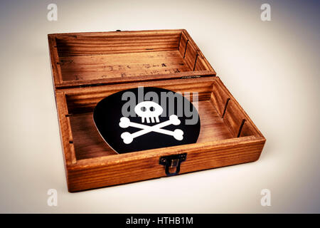 old wooden box with pirate symbol on white - skull and bones on black Stock Photo