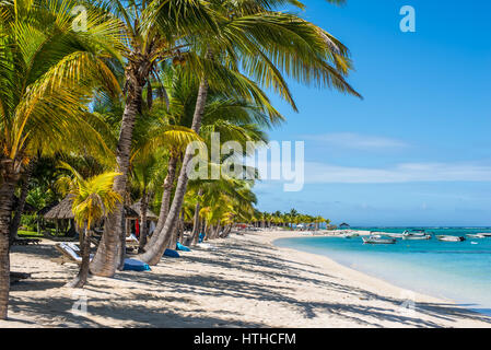 Le Morne, Mauritius - December 11, 2015: People are relaxing on the tropical Le Morne beach with coconut palms, one of the finest beaches in Mauritius Stock Photo