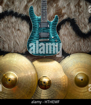 Electric guitar with three cymbals on faux fur wall. Musical instruments background Stock Photo