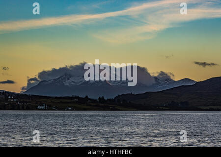 View of the snowcapped Cuillin Hills in the late afternoon sun was setting, from Bayfield Road, Portree, Isle of Skye Stock Photo