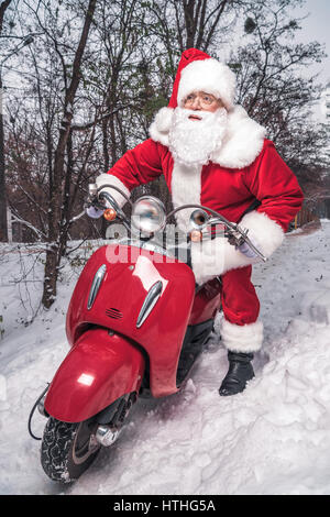 Santa Claus riding red scooter Stock Photo