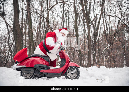 Santa Claus riding red scooter Stock Photo