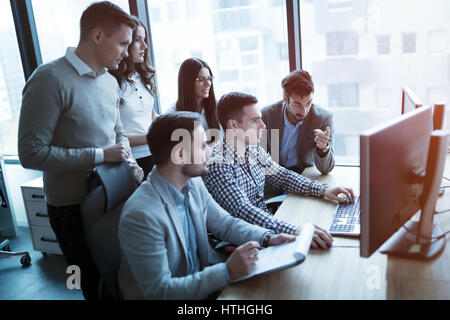 Software engineers developing applications together in office Stock Photo