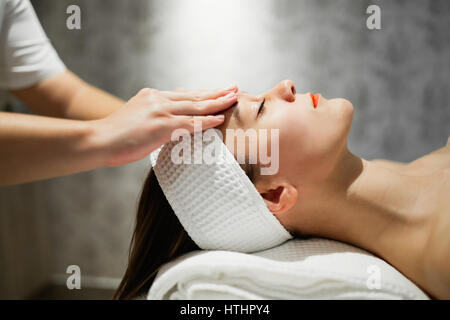 Masseuse massaging female who is relaxing at salon Stock Photo