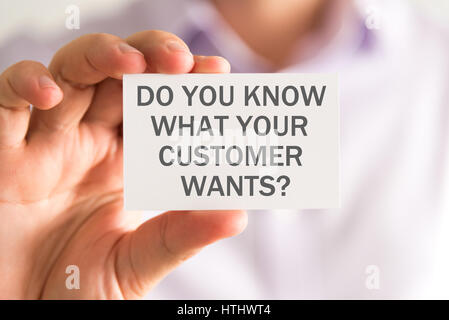 Closeup on businessman holding a card with DO YOU KNOW WHAT YOUR CUSTOMER WANTS ? message, business concept image with soft focus background Stock Photo
