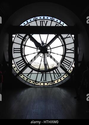 PARIS - 26 JUNE 2015: On the top floor of the Musee d'Orsay looking out of the clock onto the city of Paris. Silhouette of clock, backlit clock in for Stock Photo