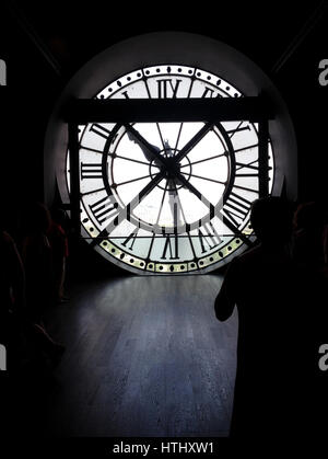 PARIS - 26 JUNE 2015:  Silhouette of tourists looking at the clock tower in the Musee d'Orsay in Paris, France,  Adaptive reuse project train station  Stock Photo