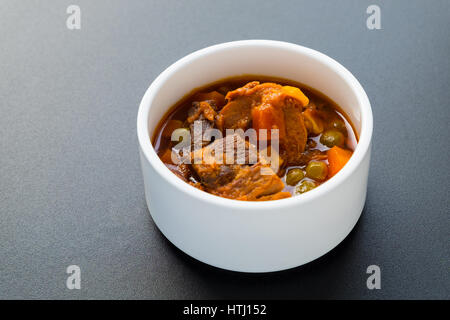 Tune steak with sauce in white cup on black table, selective focus. Stock Photo