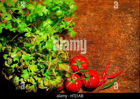 Top view of fresh herbs, tomatoes and peppers on wooden rustic bakcground with a place for an inscription. Stock Photo