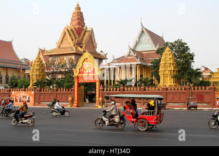 Morning traffic speeds past the Wat Ounalom temple in central Phnom Penh, Cambodia. Stock Photo