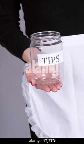 Woman's hands holding a screw cap jar for tips Stock Photo