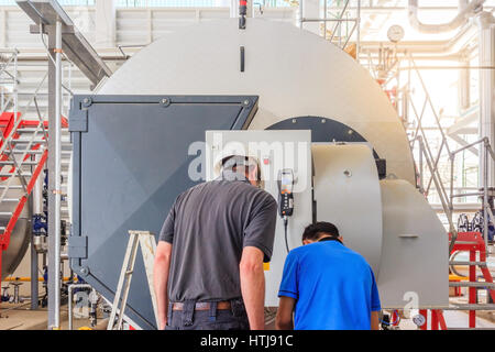 Maintenance engineer working with gas boiler of heating system equipment in a boiler room Stock Photo