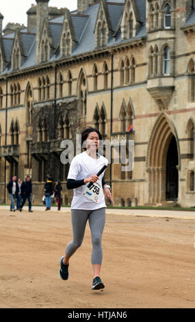 A female runner passing Christ Church College in the Teddy Hall Relays, Oxford, UK Stock Photo