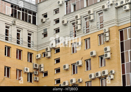 Windows and air conditioners on a modern building. Comparison with birds' nests Stock Photo