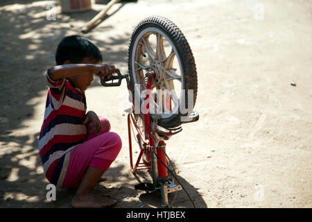 Young boy Playing With Bike in Rural Village of Preah Dak in Siem Reap - Cambodia Stock Photo