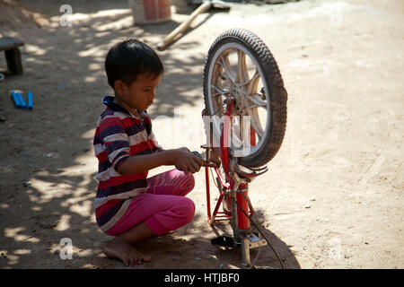 Young boy Playing With Bike in Rural Village of Preah Dak in Siem Reap - Cambodia Stock Photo