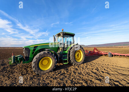 Varna, Bulgaria - March 5, 2017 Ploughing a field with John Deere tractor. John Deere was manufactured in 1995-1999 and it has JD 7.6L or 8.1L 6-cyl d Stock Photo