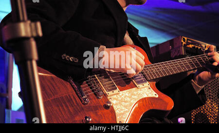 Guitar player plays the electric guitar on the stage. Jazz or rock concert performance entertainment. Close up shot with selective focus. Stock Photo