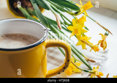 Spring flowers daffodils with a cup of coffee, cappuccino and close-up Stock Photo