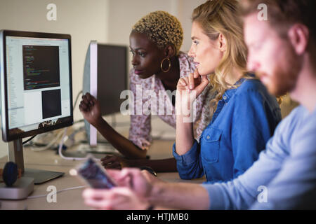 Programmers cooperating at  IT company developing apps Stock Photo