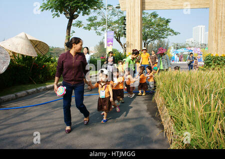 Ho Chi Minh city, Viet Nam, Asian kid in outdoor activity of preschool, boy, girl in uniform, Vietnamese children visit park in springtime, Vietnam Stock Photo