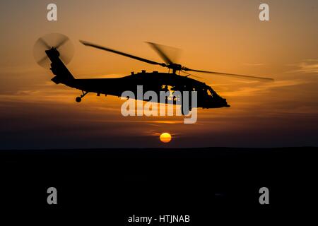 A U.S. Navy MH-60 Seahawk helicopter silhouetted against the sunset outside of Camp Buehring January 16, 2017 in Udari, Kuwait.        (photo by MCS2 Corbin J. Shea /US Navy  via Planetpix)