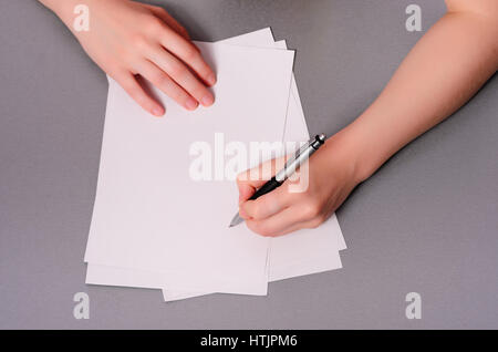 Human hands with pencil writing on paper and erase rubber on wooden table Stock Photo