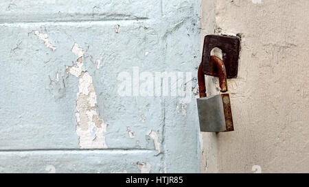 The rusty key lock hangs on a gate. Stock Photo