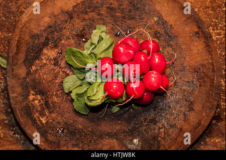 Top view of bunch of fresh organic radish in a plate on wooden plate