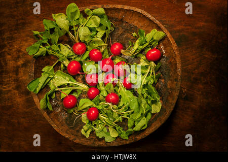 Top view of fresh organic radish in a plate on wooden table