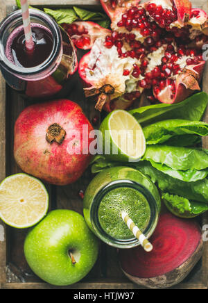 Close-up of green and purple fresh juices with fruits, vegetables Stock Photo
