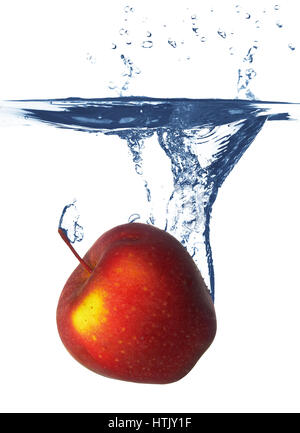 Apple falls deeply under water with a big splash. Stock Photo