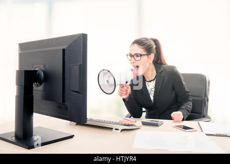 Businesswoman yelling through a megaphone Stock Photo