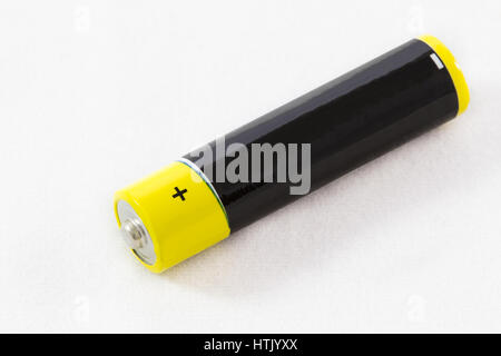 Close-up of one diagonally-arranged yellow black AAA alkaline battery isolated on a white background Stock Photo