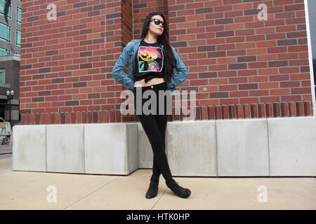 latina teenage girl in black leggings, top and jacket posing on