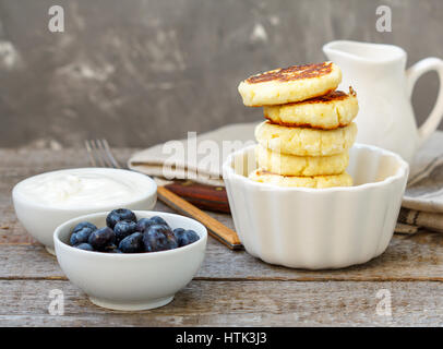 Cottage cheese pancakes for breakfast with blueberries and sour cream. Stock Photo